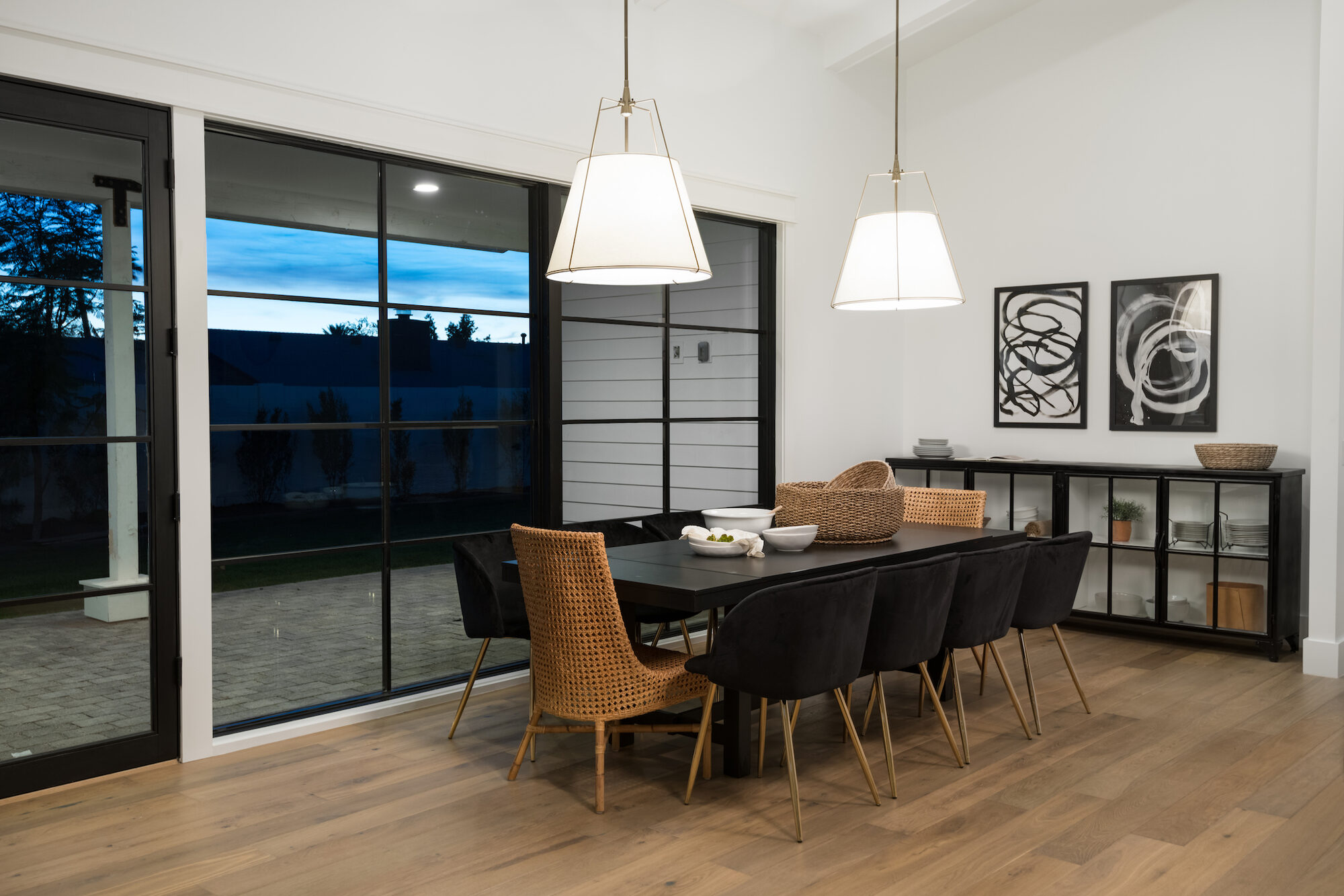 Formal dining room with a black table, mixed seating, and large glass doors to a patio