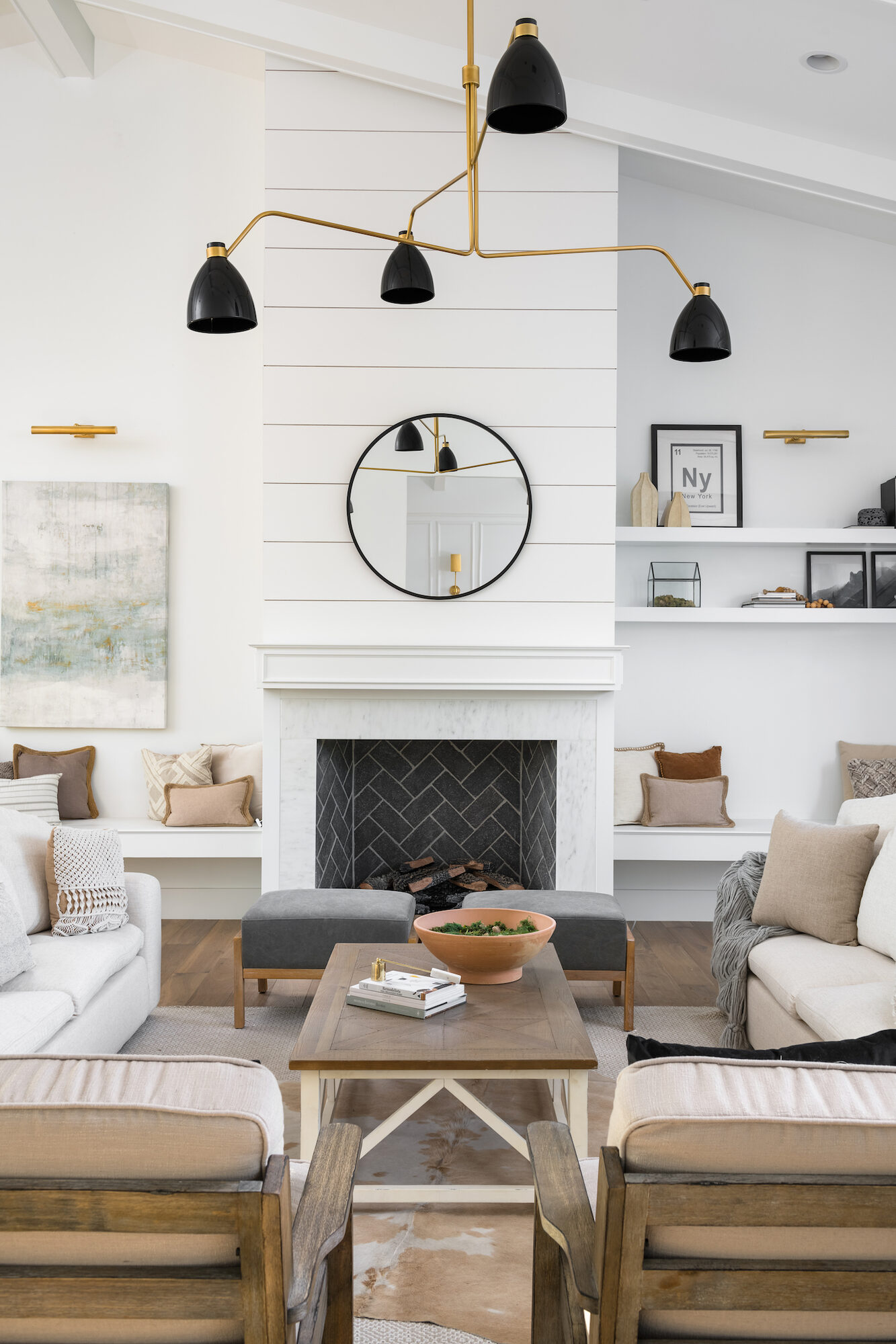 Living room centered on a shiplap fireplace surround with brass and black fixtures