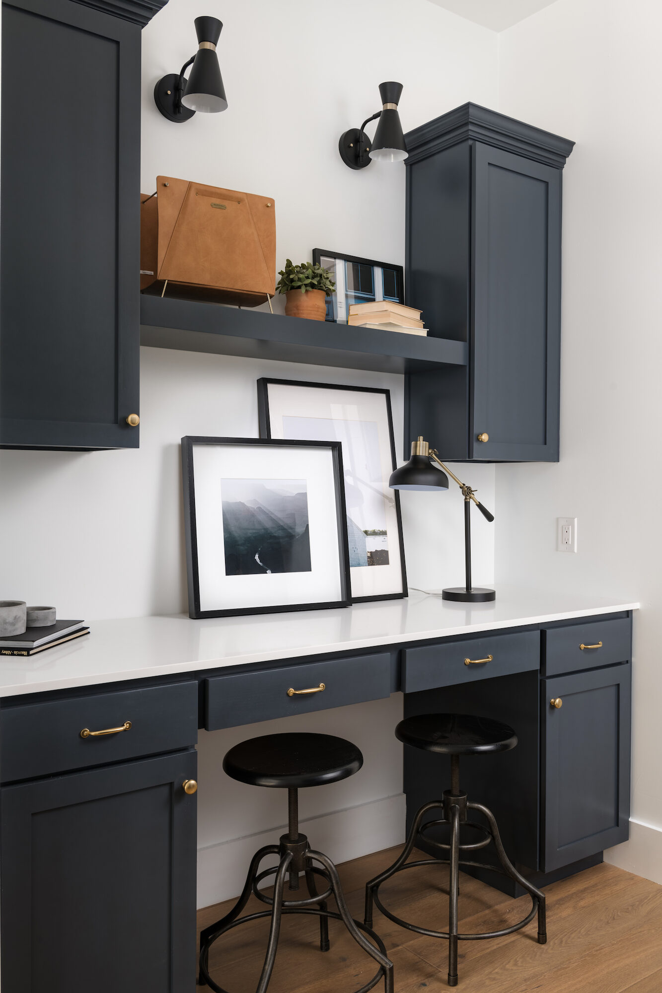 Built-in study with navy cabinetry, brass hardware, and custom shelving